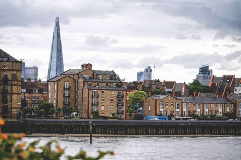View of London skyline with The Shard and historic residential buildings along the river, highlighting the safest neighborhoods to live in London.