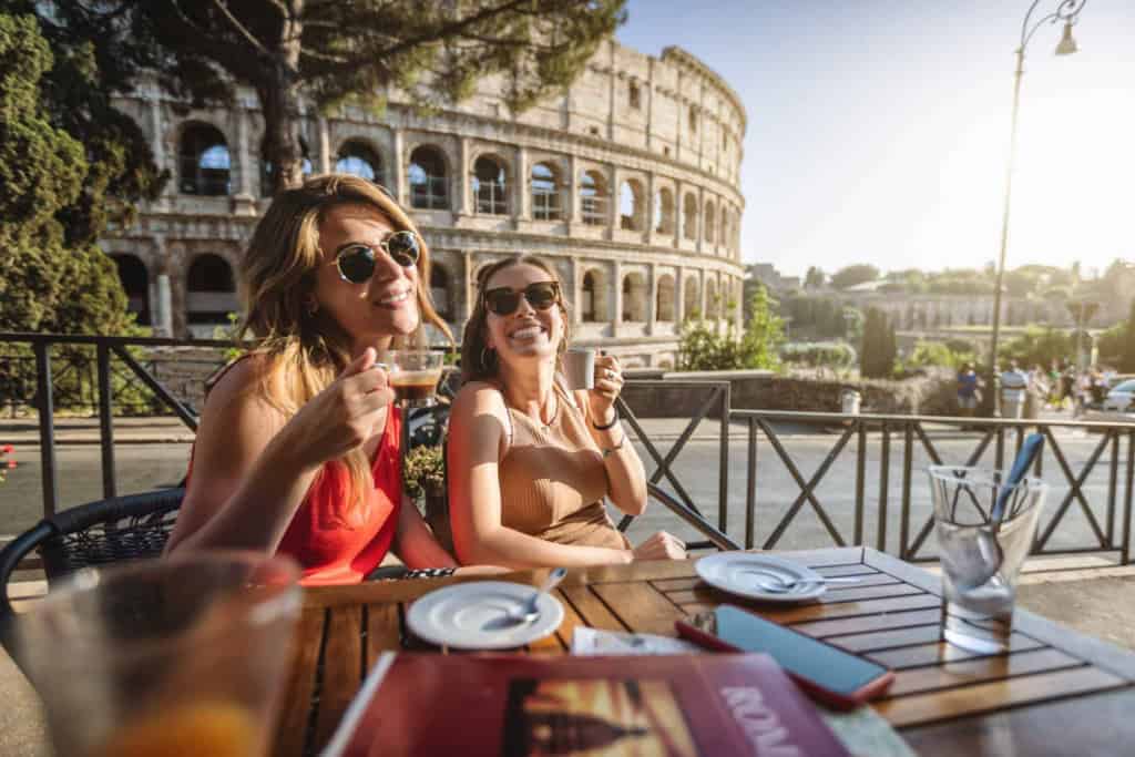 two women drinking at a cafe in Rome, which has one of the highest cost of living in Italy