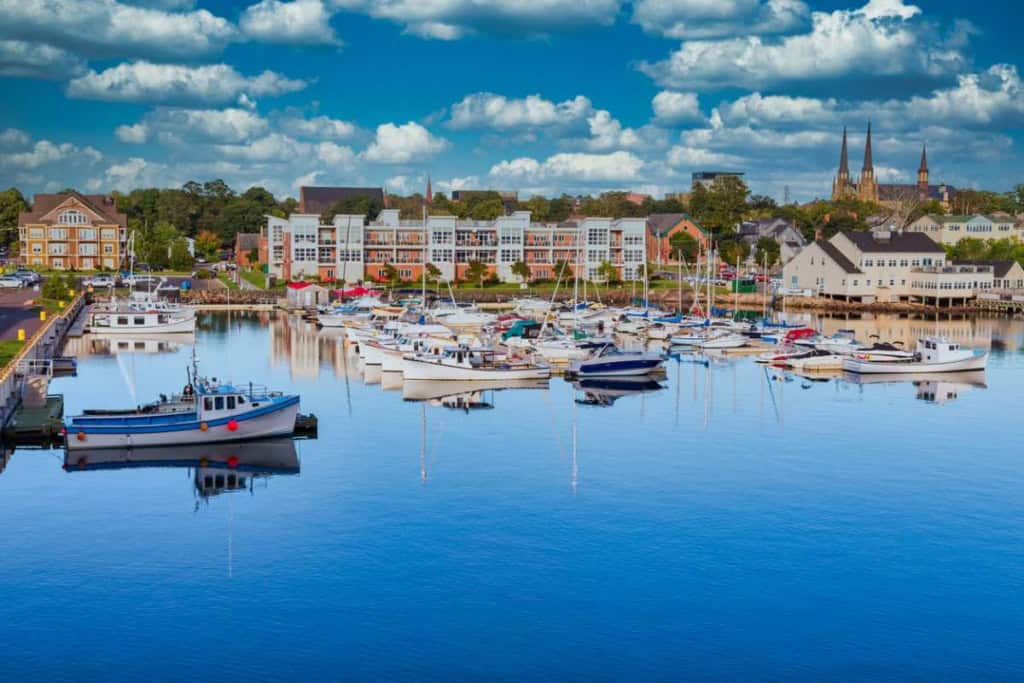 Scenic view of a marina in Canada with boats docked and a cityscape in the background, perfect for those planning to move to Canada and seeking information on international insurance options.