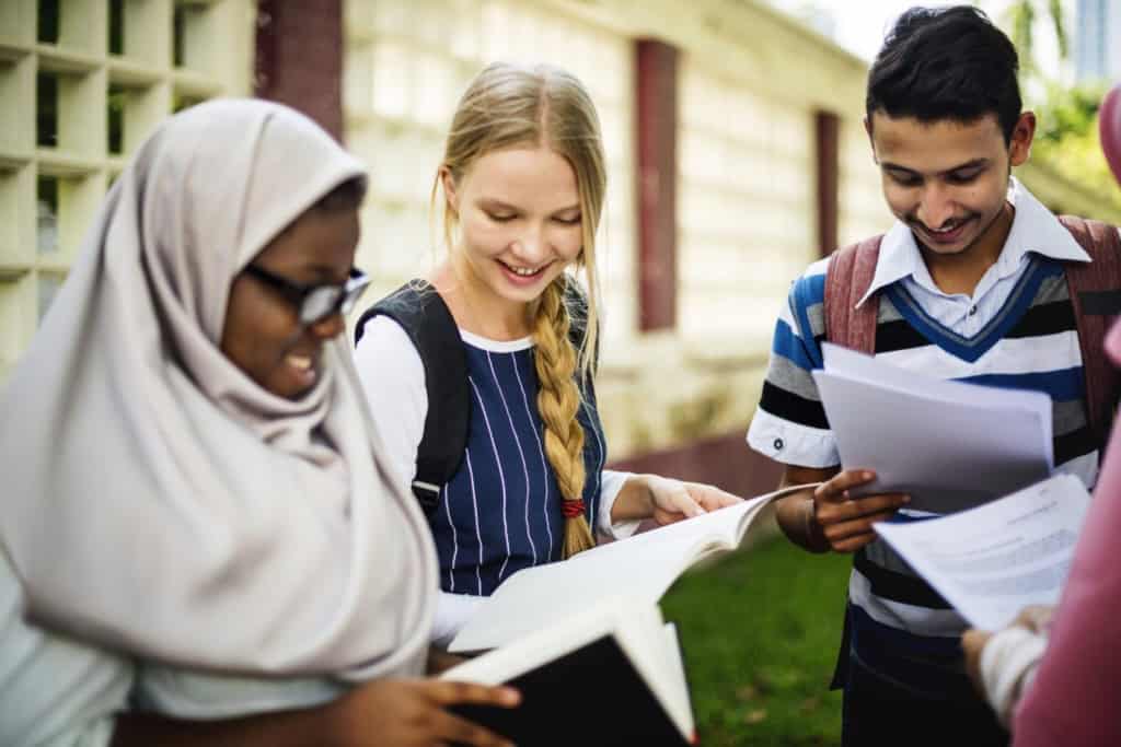Group of diverse students studying outdoors, highlighting international education and global living costs in Indonesia.