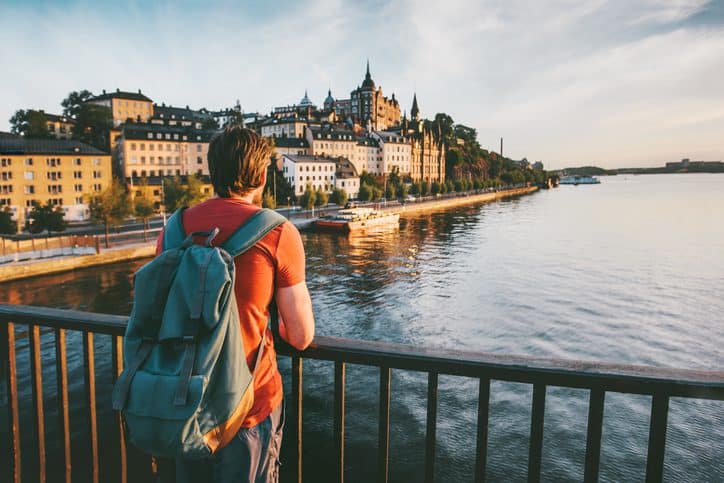 Traveling traveler overlooking a historic European cityscape by the river.