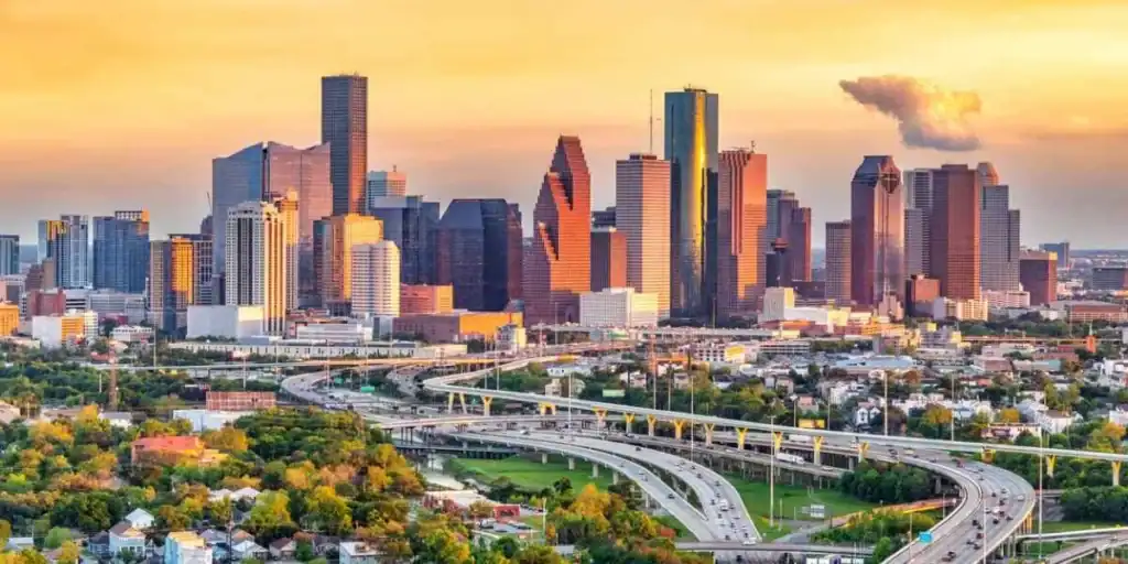 A panoramic view of downtown U.S. city skyline during sunset, highlighting modern skyscrapers and urban landscape.