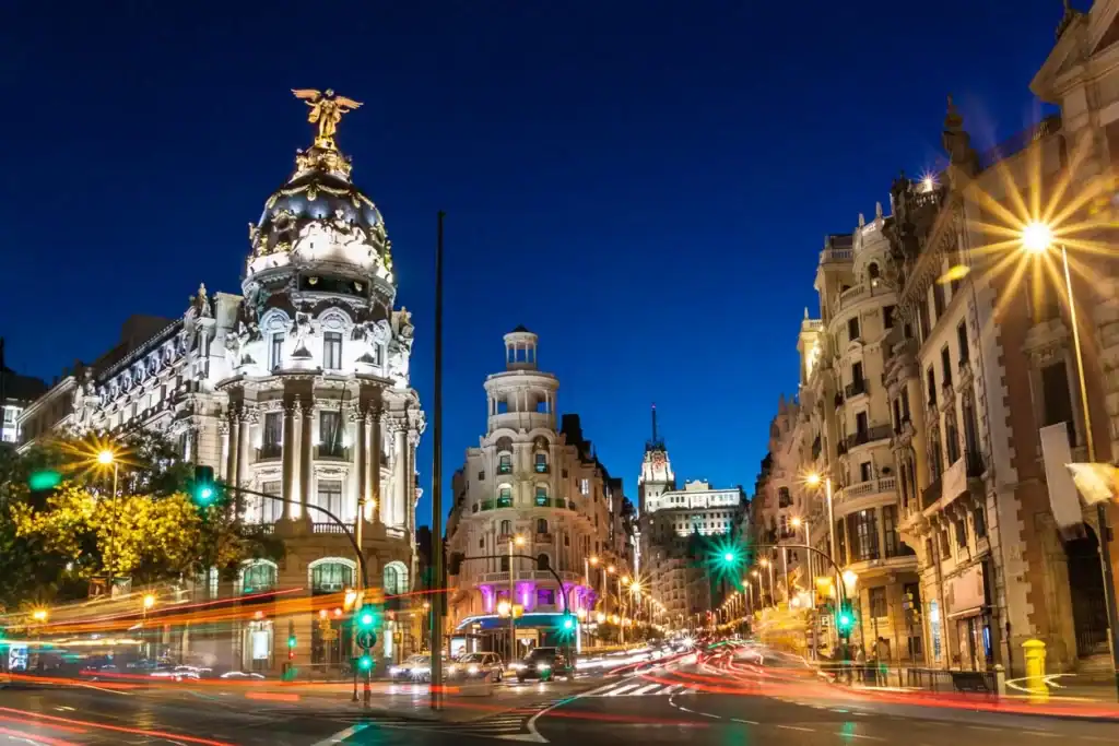Madrid City Hall and Gran Vía at night, illuminated with vibrant city lights.