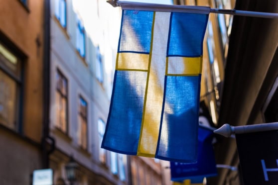 Swedish flag hanging between buildings in a city street, symbolizing Sweden's culture and national identity.