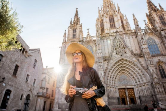 Expat woman enjoying her time in front of Barcelona's iconic Gothic Cathedral, highlighting the vibrant lifestyle and cultural richness for international residents.