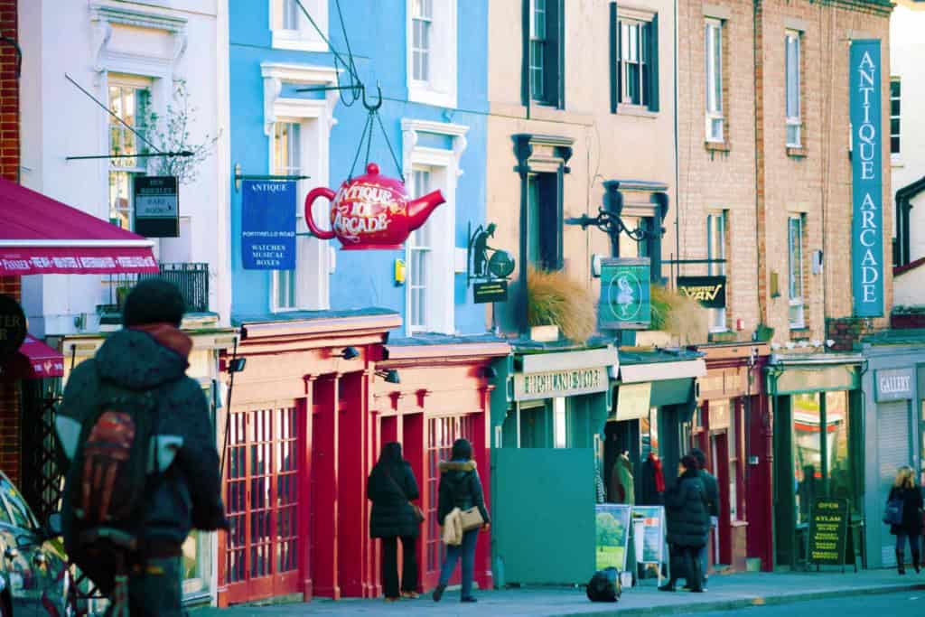 An image showcasing a vibrant street in a safe London neighborhood with colorful shops and pedestrians, highlighting the appeal of secure living areas in the city.