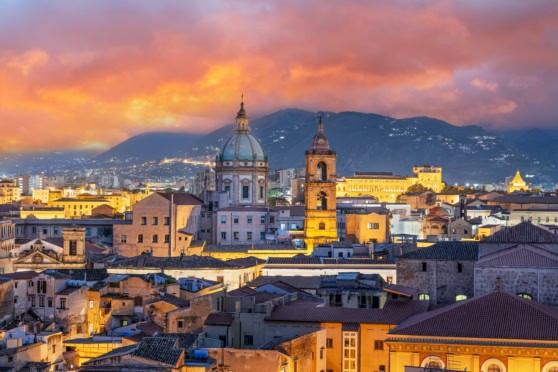 Beautiful sunset view over historic Italian cityscape with domes and towers.