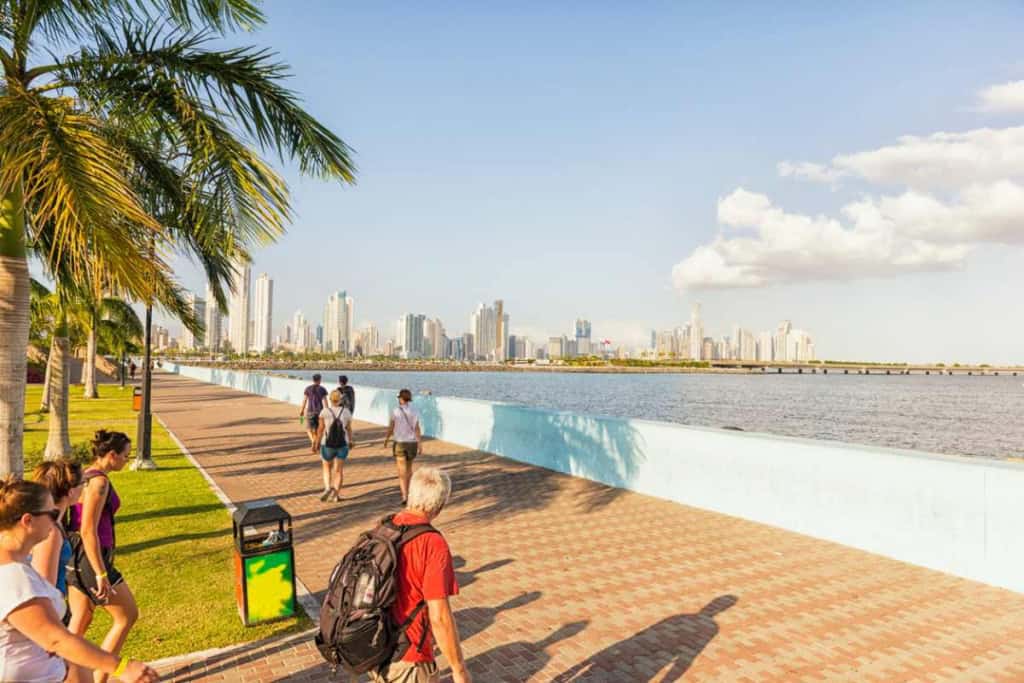 Scenic view of Panama City skyline from the waterfront promenade with tourists walking along the path, one of the best places to retire in Panama