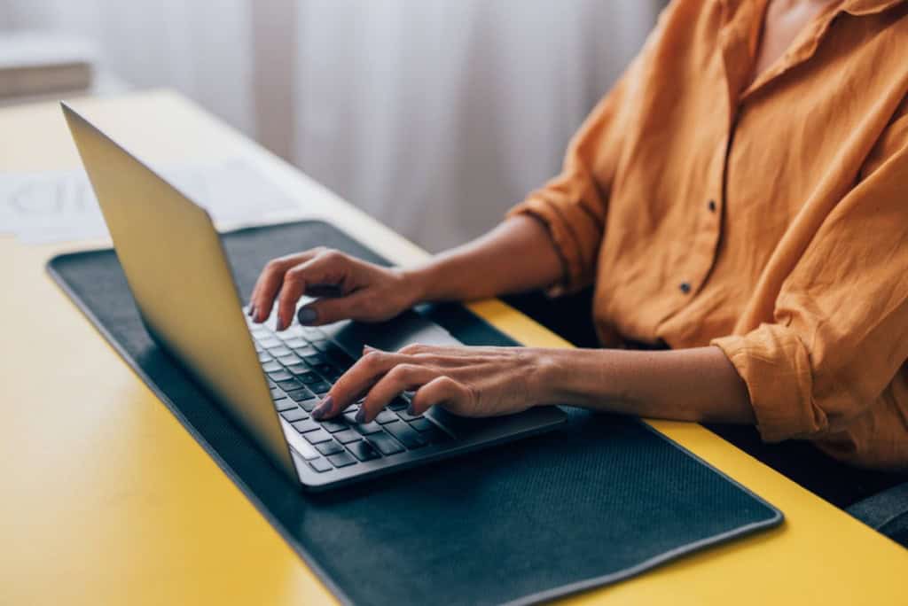 An individual using a laptop to explore insurance plans related to relocating to Canada.