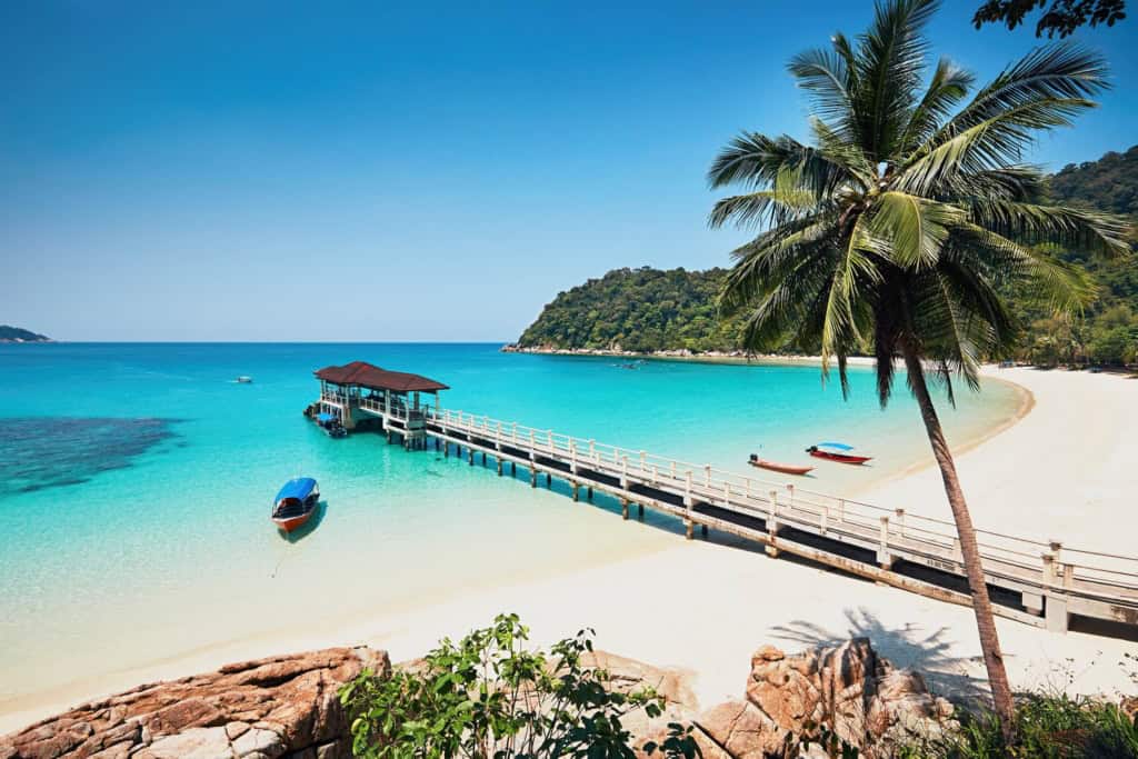 Beach with palm trees and clear turquoise waters in Malaysia.