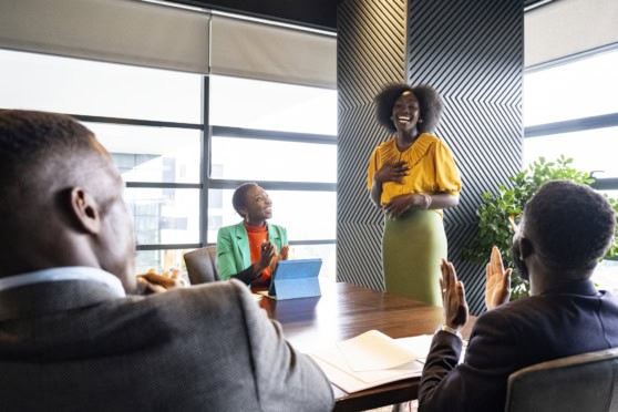 Diverse group of professionals in a business meeting, discussing insurance options in a modern office setting.