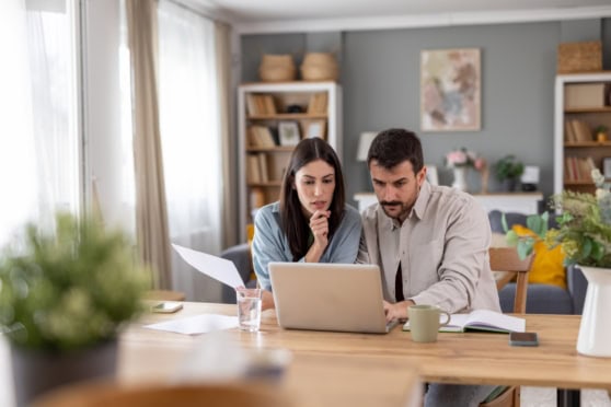 American expats reviewing tax documents and digital resources at home, emphasizing international tax compliance and financial planning.