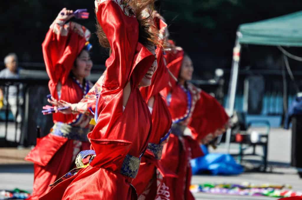 Celebrating traditional dance at a summer festival, showcasing colorful costumes and lively performances in an outdoor setting.
