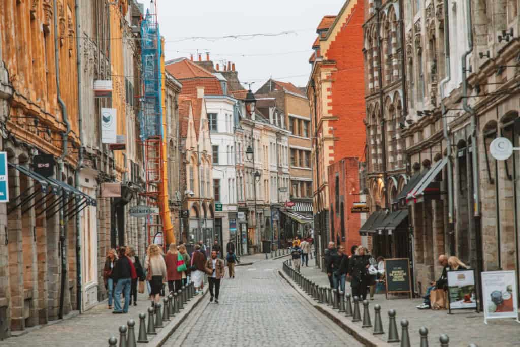Pedestrians walking along a historic street in Lille, France