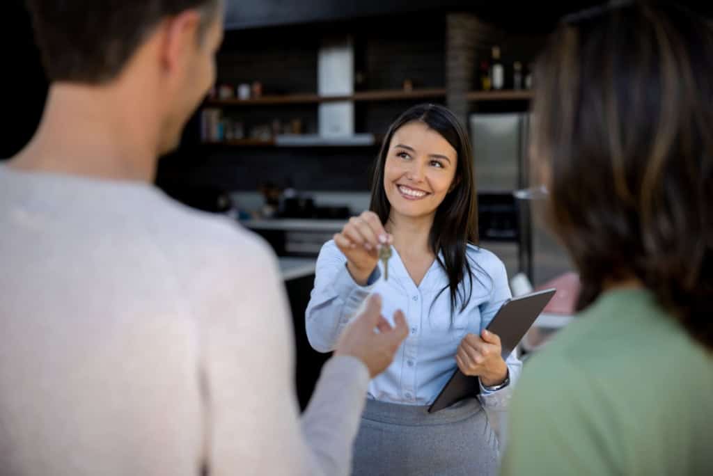 An agent explains property options to a couple interested in buying property abroad
