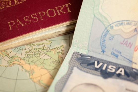 Close-up of a passport, visa, and travel documents on a map, representing international travel and global mobility.