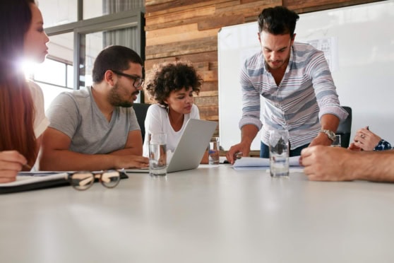 Group of diverse professionals in a meeting room discussing international work strategies, with a focus on global mobility and expatriate planning.