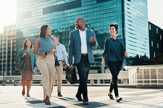 Business travelers walking in a modern city with glass skyscrapers, representing international mobility and expatriate lifestyle.