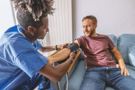 Traveler receiving a blood pressure check abroad, illustrating how travel health insurance can help with unexpected medical care.