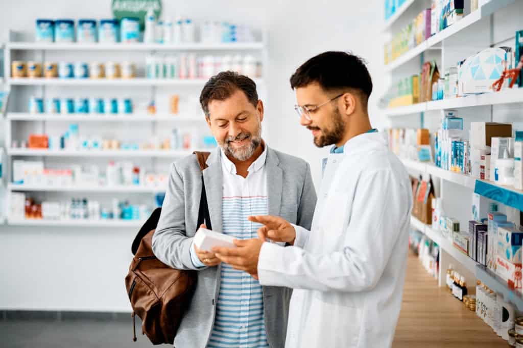 A traveler getting help from a pharmacist with medication during a trip abroad