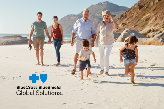 Family enjoying a beach walk in California with mountains in the background.