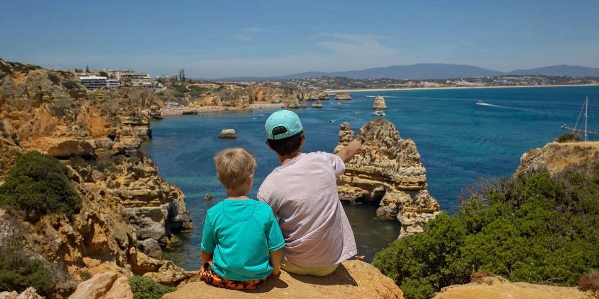 algarve-portugal A family sitting by the coast in Greece, one of the best family vacations ideas for 2025