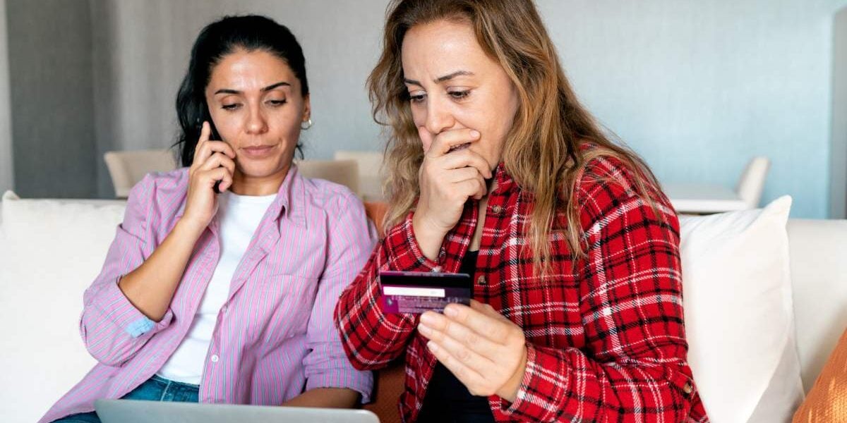 credit-card-fraud an upset woman holding her bank card as she realises she's fallen victim to one of the most common travel scams
