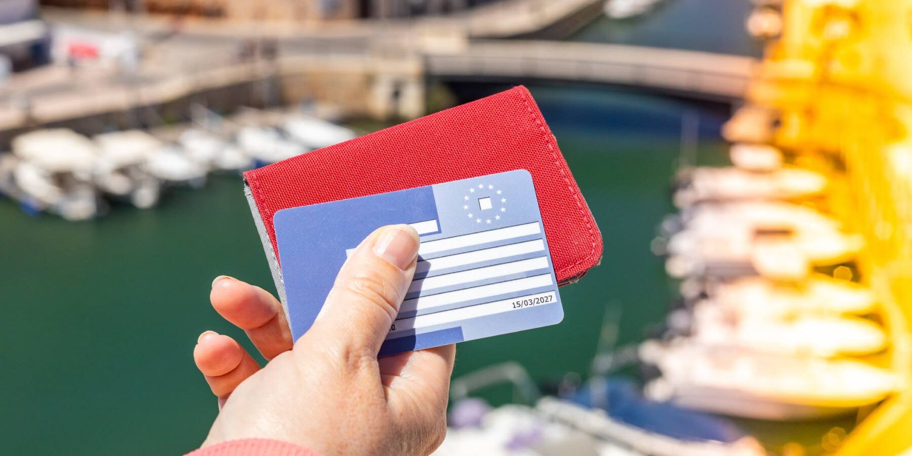 european-health-insurance-card A woman holding a European health insurance card (EHIC) to access healthcare in the European Union and EFTA countries
