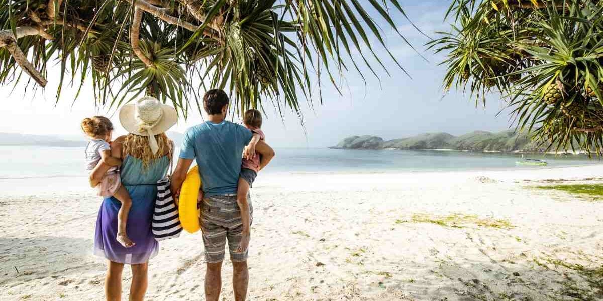 family-beach-indonesia a family walking on a beach on Nikoi Island in Indonesia, one of the best family vacation ideas for 2025