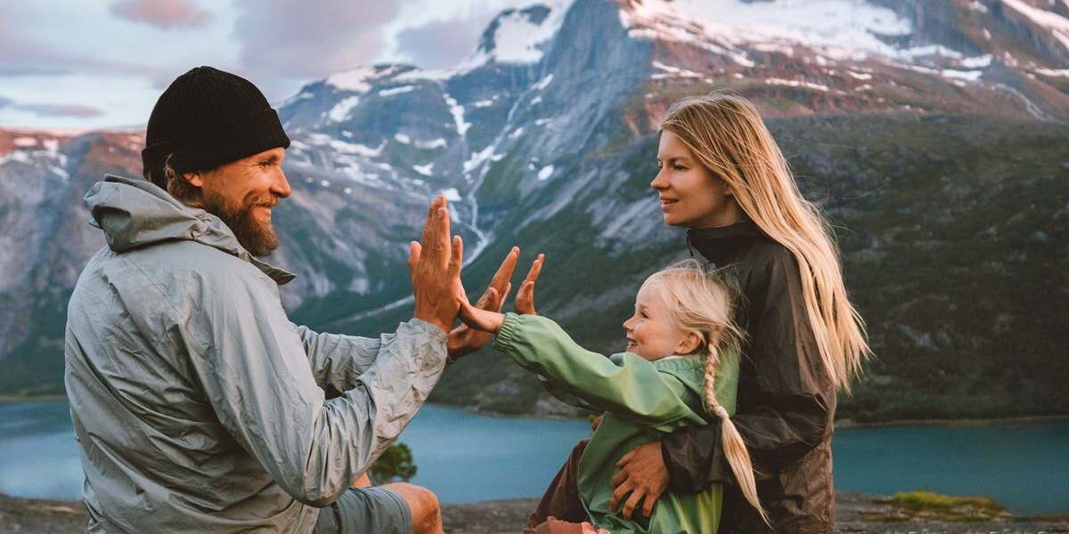 family-norway-mountains a mother, father and child sitting overlooking the mountains in Norway, one of the healthiest countries in the world