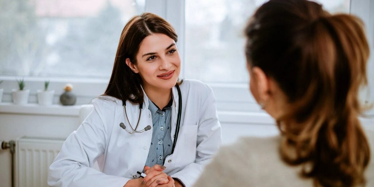 female-doctor-with-patient a female doctor talking to a patient, indicating the importance of getting health insurance after becoming an expat