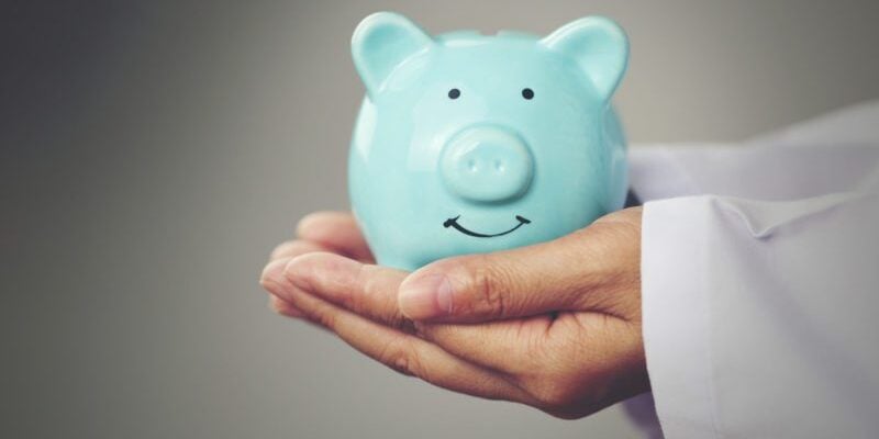 International Health Insurance Saves Money in the US - doctor's hands holding piggybank