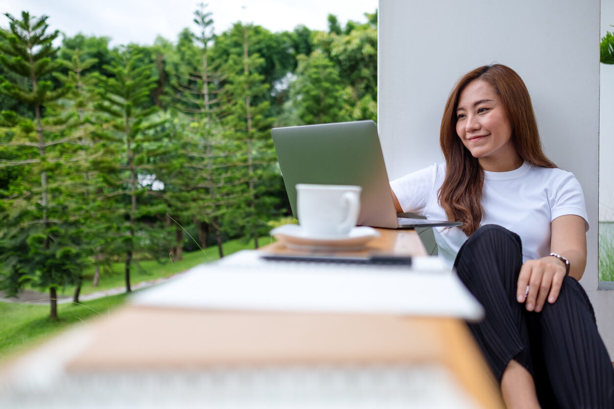 Digital nomad on her laptop outdoors finding the right insurance