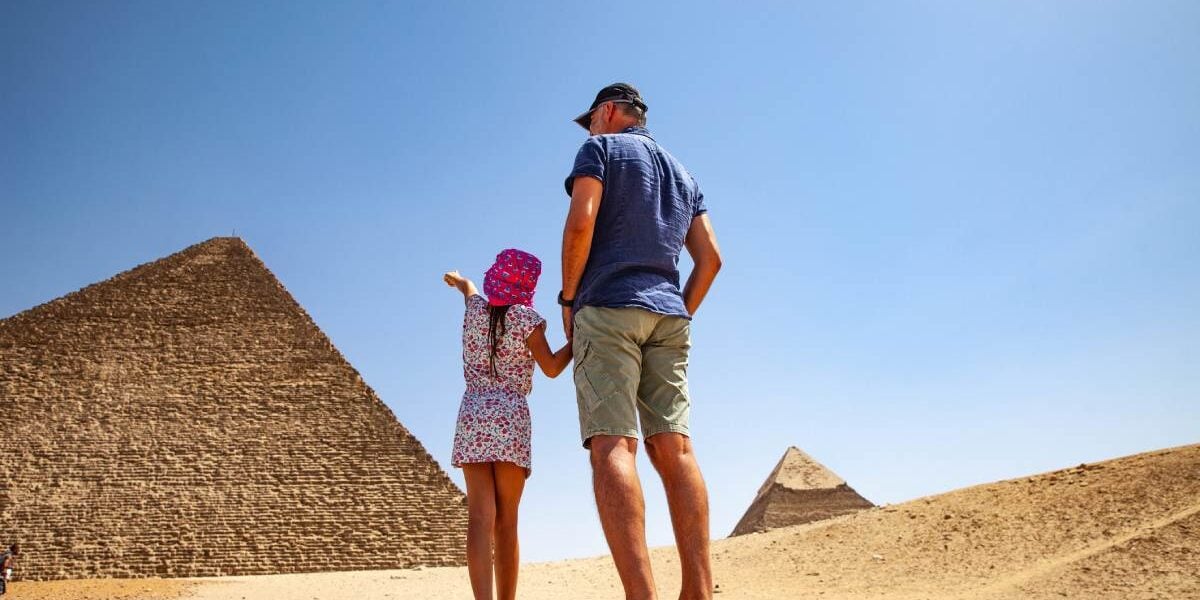 pyramids-egypt a father and daughter looking at the pyramids in Cairo, one of the best family vacation ideas for 2025