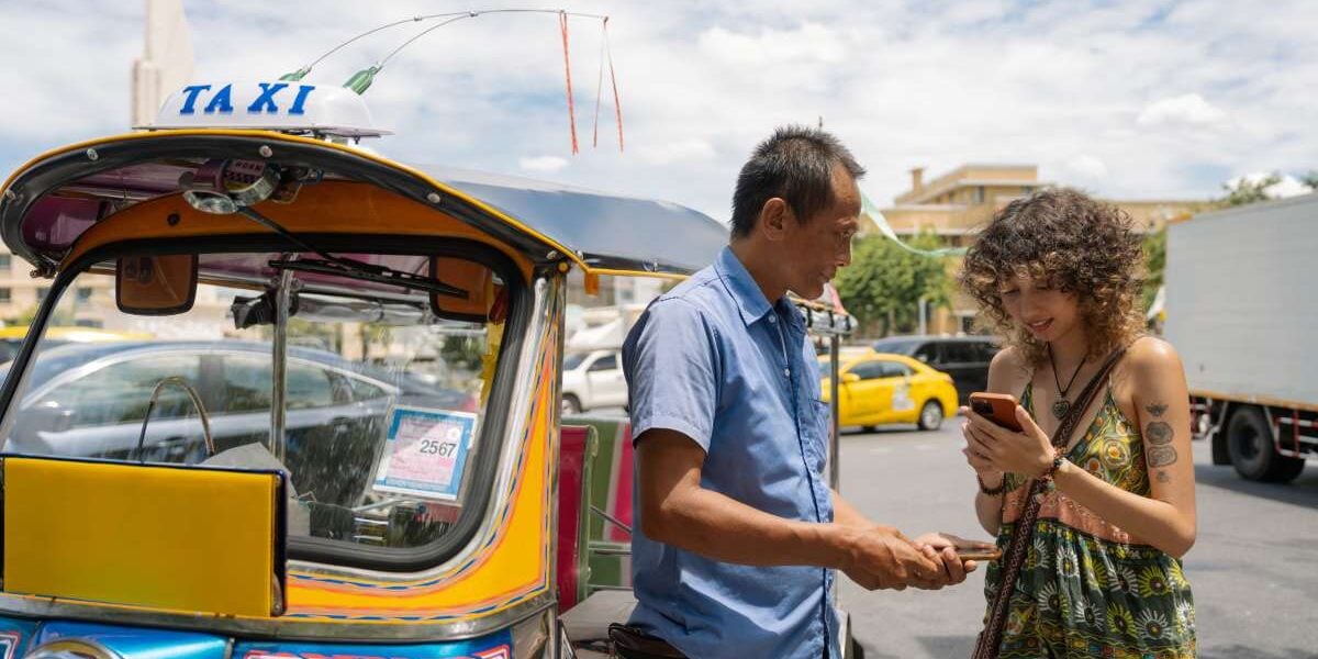 tuk-tuk-travel-scam a female traveler trying to avoid one of the common tuk tuk travel scams in Thailand