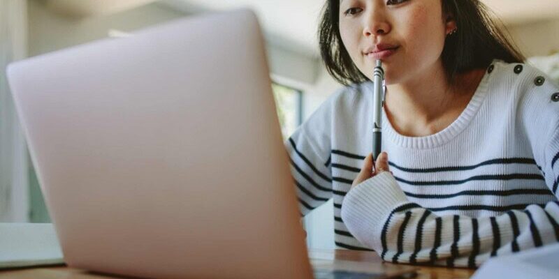 woman-researching-online a woman researching travel insurance on her laptop after asking does my health insurance cover international travel